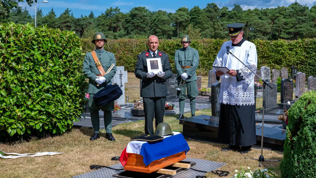 De aalmoezenier leidt de herbegrafenis.