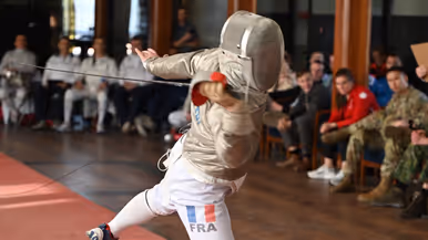 Schermer in actie met publiek zittend op de achtergrond.