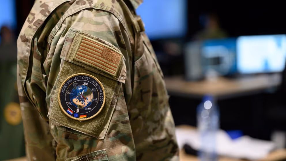 Een uniform met het embleem van de oefening Joint Project Optic Windmill op de mouw.