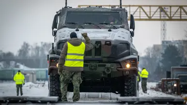 Nederlandse militairen lossen voertuigen die per trein in Litouwen zijn aangekomen. 