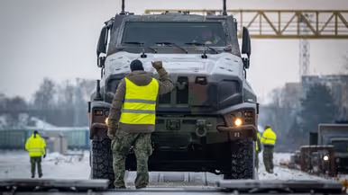 Nederlandse militairen lossen voertuigen die per trein in Litouwen zijn aangekomen. 