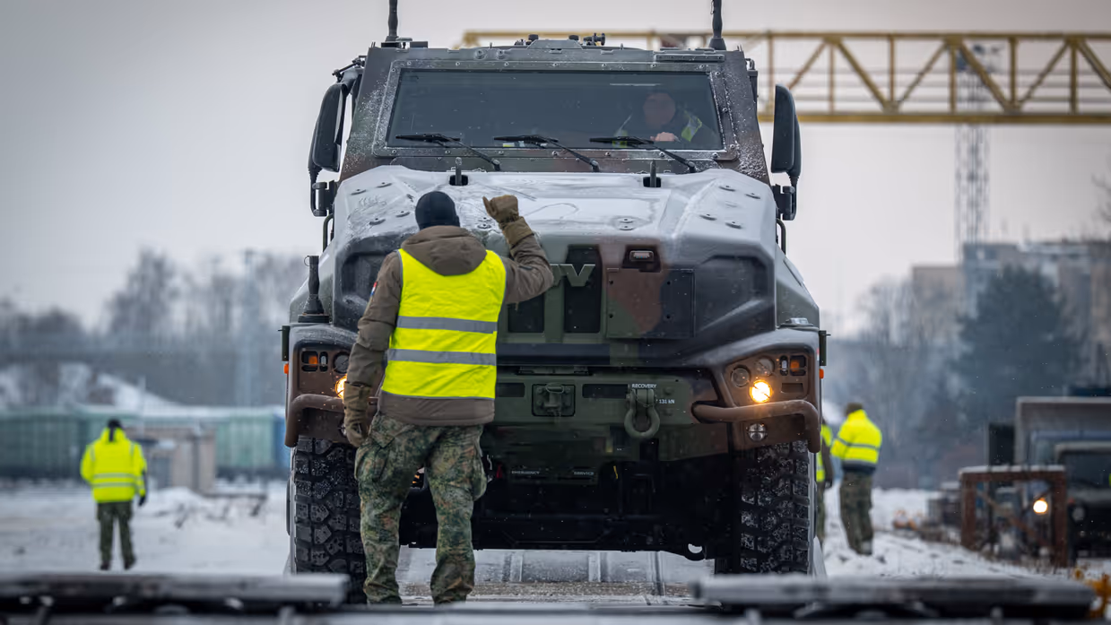 Nederlandse militairen lossen voertuigen die per trein in Litouwen zijn aangekomen. 