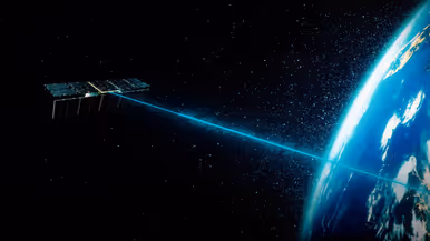 Op beide foto’s is een satelliet in de ruimte te zien. Een wat grotere stuurt een lasterstraal naar de aarde. De wat kleinere heeft een deels gouden behuizing.&nbsp;