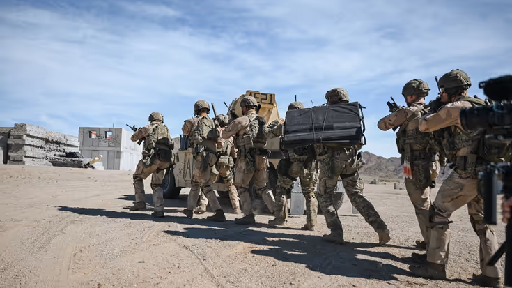 Een groep militairen gaat in colonne voorwaarts. 