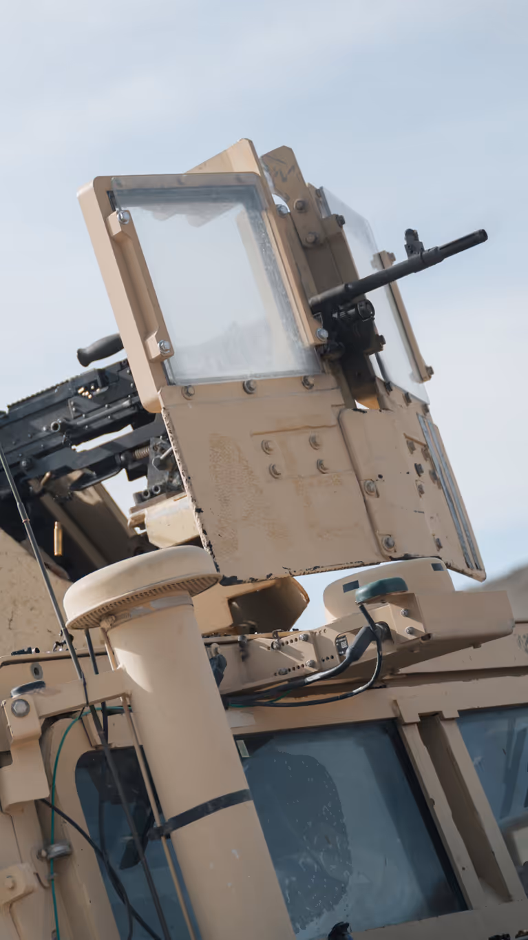 Een schutter kijkt door zijn vizier bovenop een voertuig. 