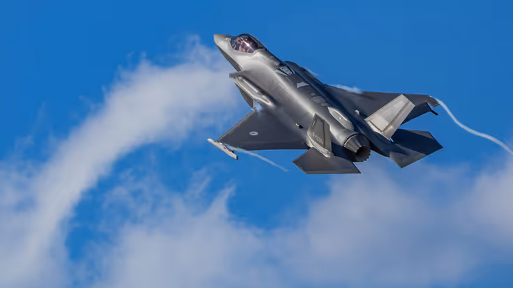 Een F-35-gevechtsvliegtuig vliegt door een strakblauwe lucht.