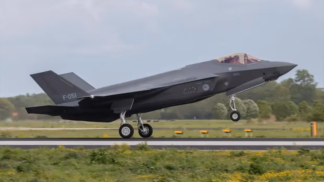 Een grijs F-35-jachtgvliegtuig stijgt op vanaf een start- en landingsbaan.    