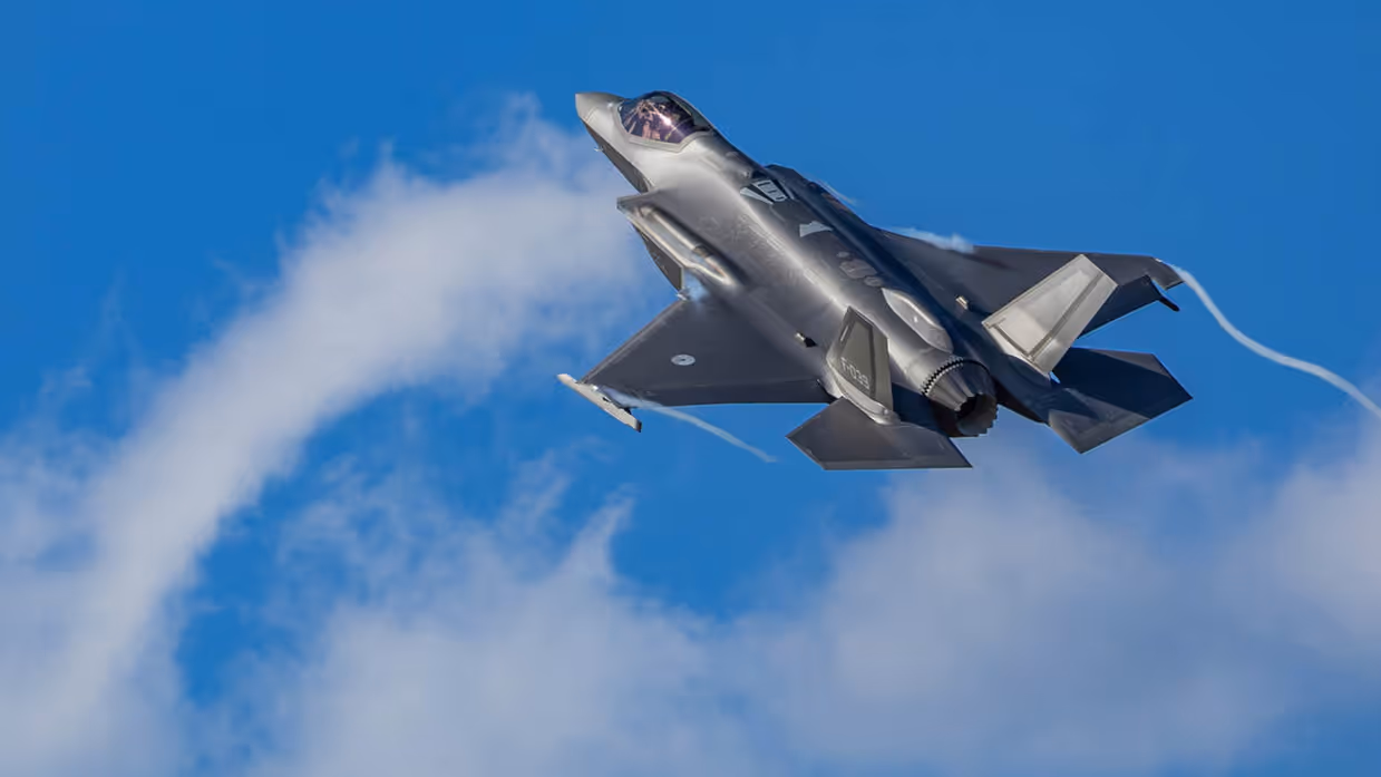 Een F-35-gevechtsvliegtuig vliegt door een strakblauwe lucht.
