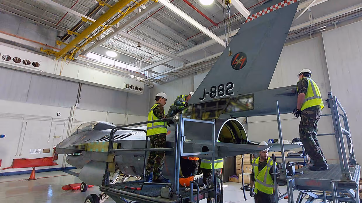 Mensen werken aan een militair vliegtuig.