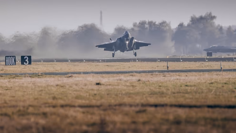 F-35 met neus omhoog vlak boven de grond van landingsbaan.