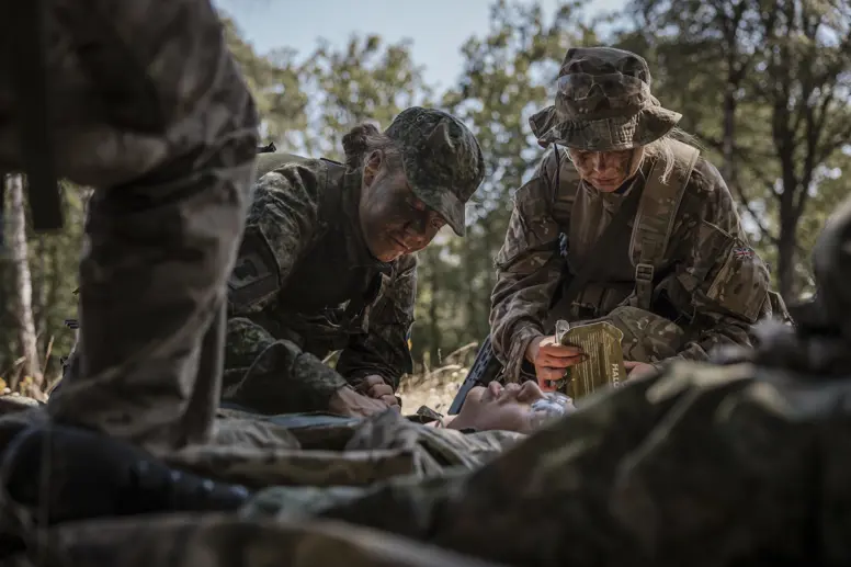 Militairen behandelen gewonde collega tijdens oefening.