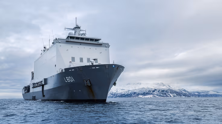 Vooraanzicht van Zr.Ms. Johan de Witt tegen de achtergrond van de Noorse kust.