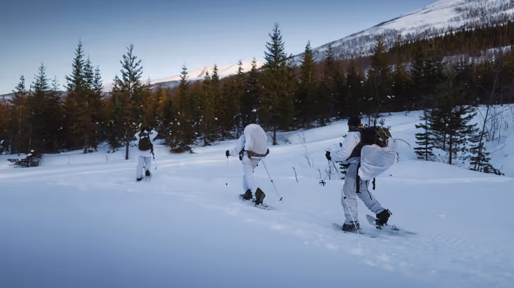 Drie mariniers verplaatsen zich op ski’s in een Noors sneeuwlandschap. &nbsp; &nbsp;