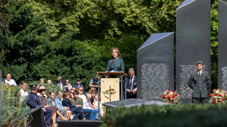 De minister spreekt tijdens de herdenking.