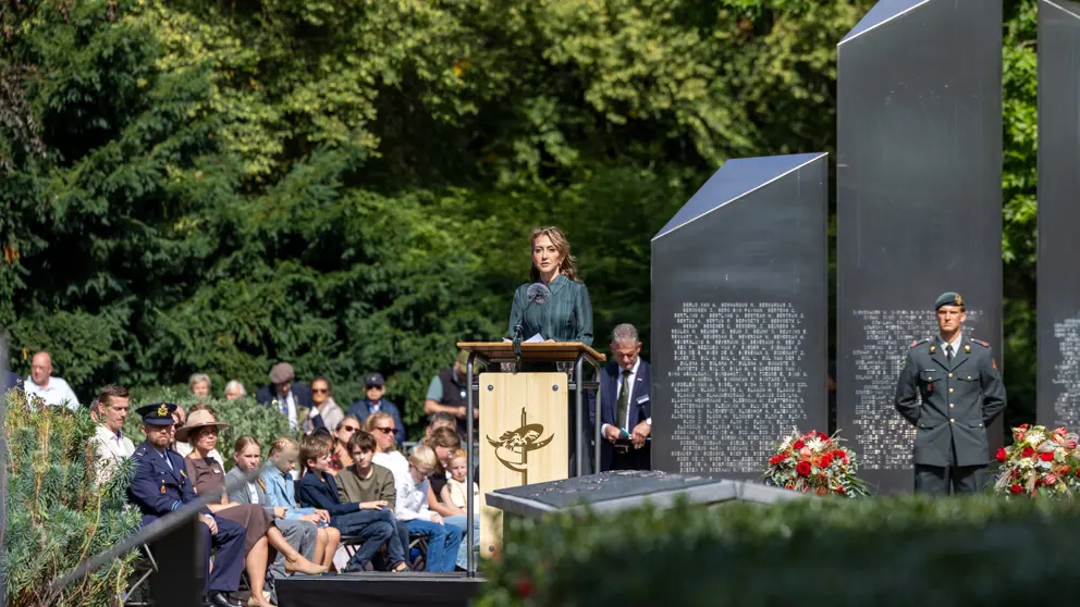 De minister spreekt tijdens de herdenking.