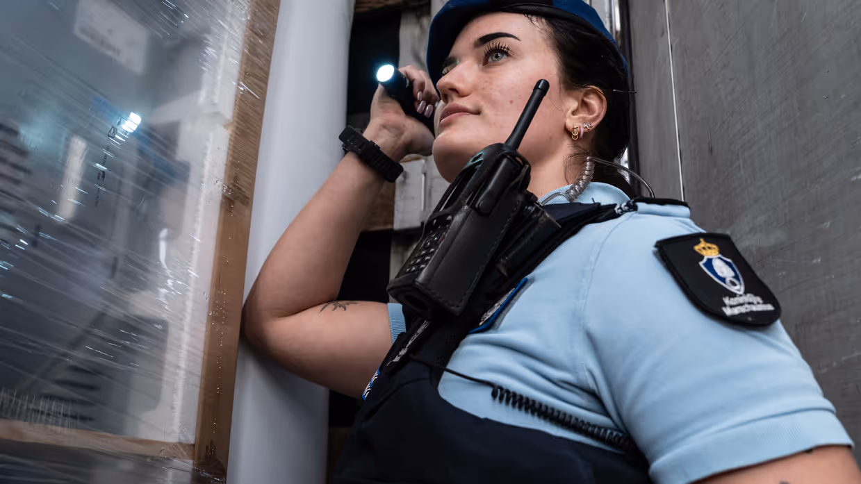 Een marechaussee schijnt met een zaklamp in een voertuig.