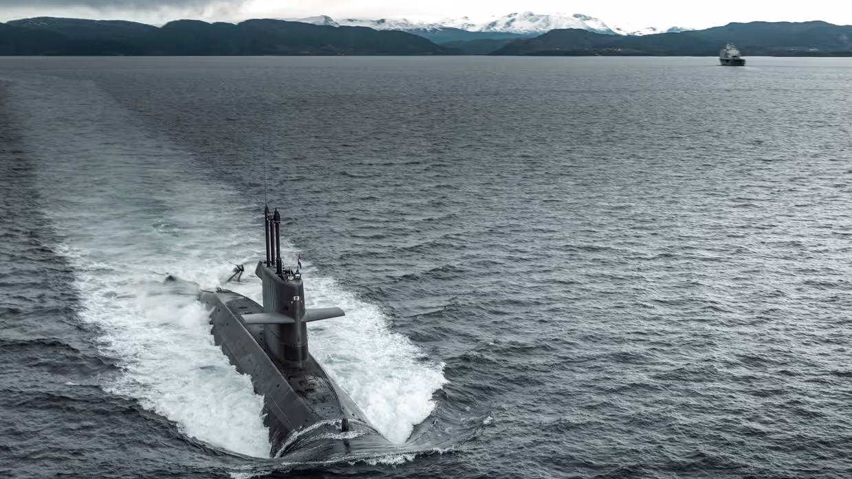 Een onderzeeboot van de Walrusklasse van bovenaf gezien varend door een fjord.