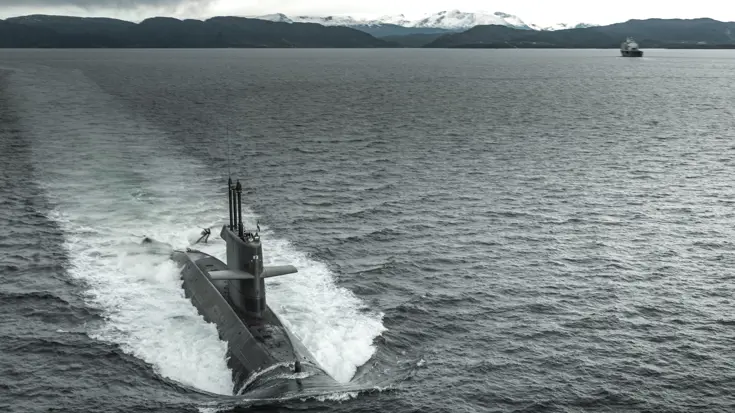 Een onderzeeboot van de Walrusklasse van bovenaf gezien varend door een fjord.