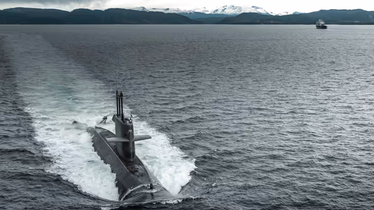 Een onderzeeboot van de Walrusklasse van bovenaf gezien varend door een fjord.