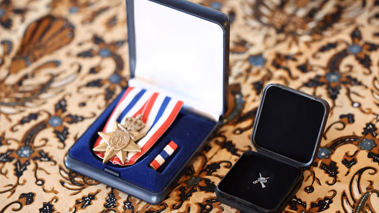 2 eretekens liggen in doosjes. Op de ondergrond een Indisch kleedje.