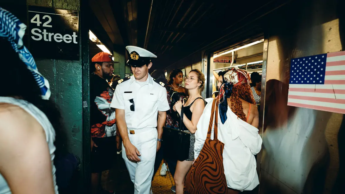 Artistieke plaat van een marineman in de metro met rechts van hem een dame. 