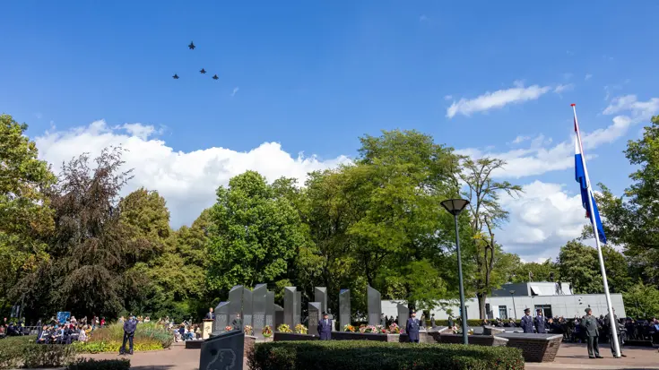 Vier straaljagers vliegen over de herdenking.