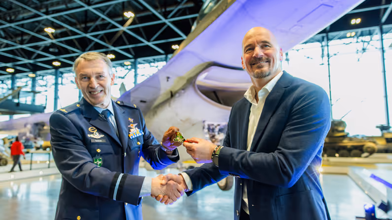 Twee mannen tijdens het moment waarop een coin werd overgedragen. 