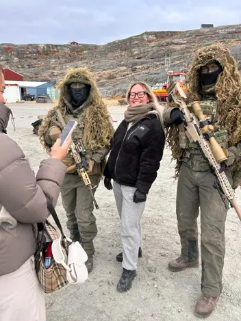 Een Groenlandse poserend met twee snipers.  
