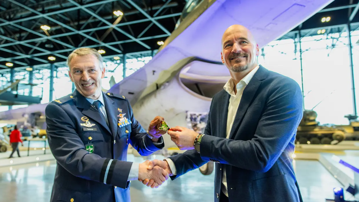 Twee mannen tijdens het moment waarop een coin werd overgedragen. 