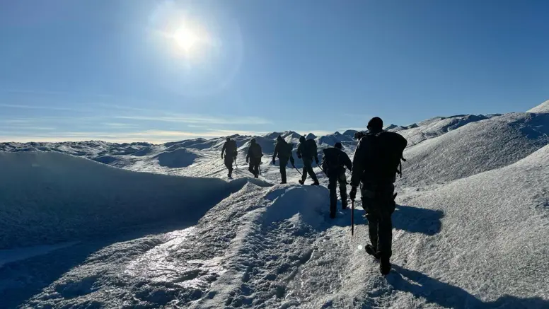 mariniers achter elkaar lopend in een weids wit landschap. 