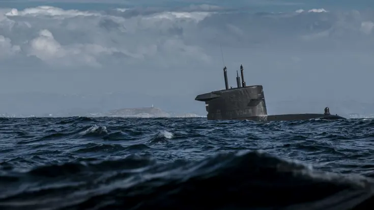 Een onderzeeboot komt schuin omhoog uit het water.