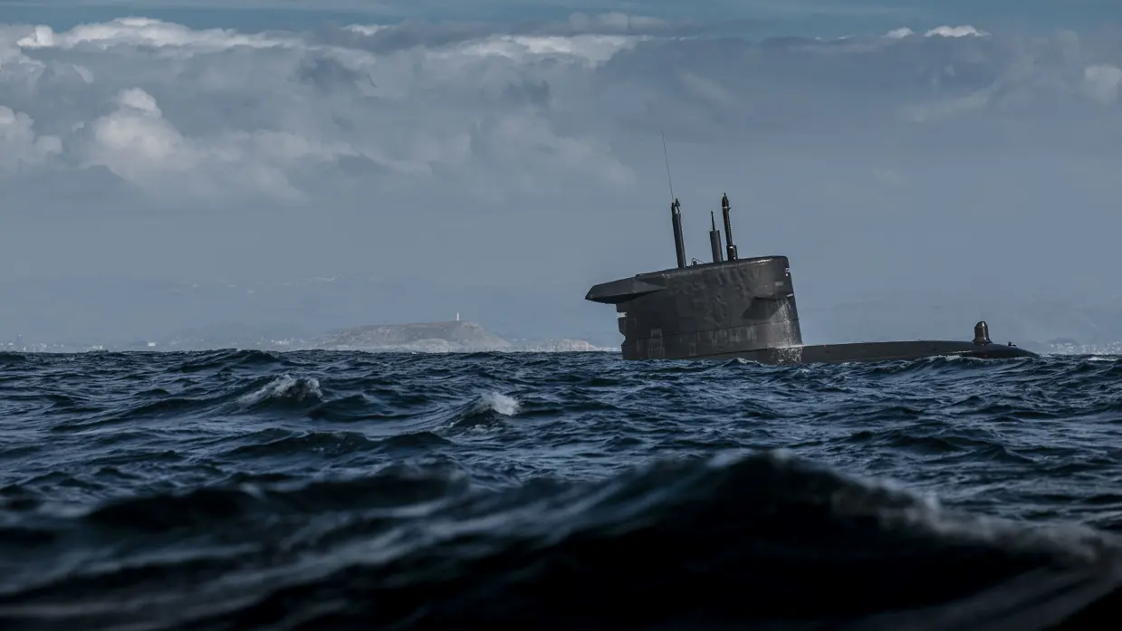 Een onderzeeboot komt schuin omhoog uit het water.
