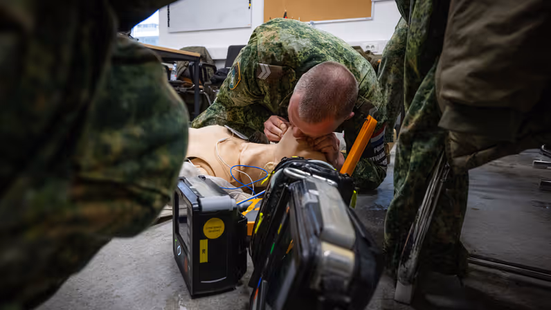 Een marechaussee die een pop mond-op-mondbeademing geeft.  