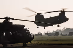 Chinook-transporthelikopter landt op open veld.