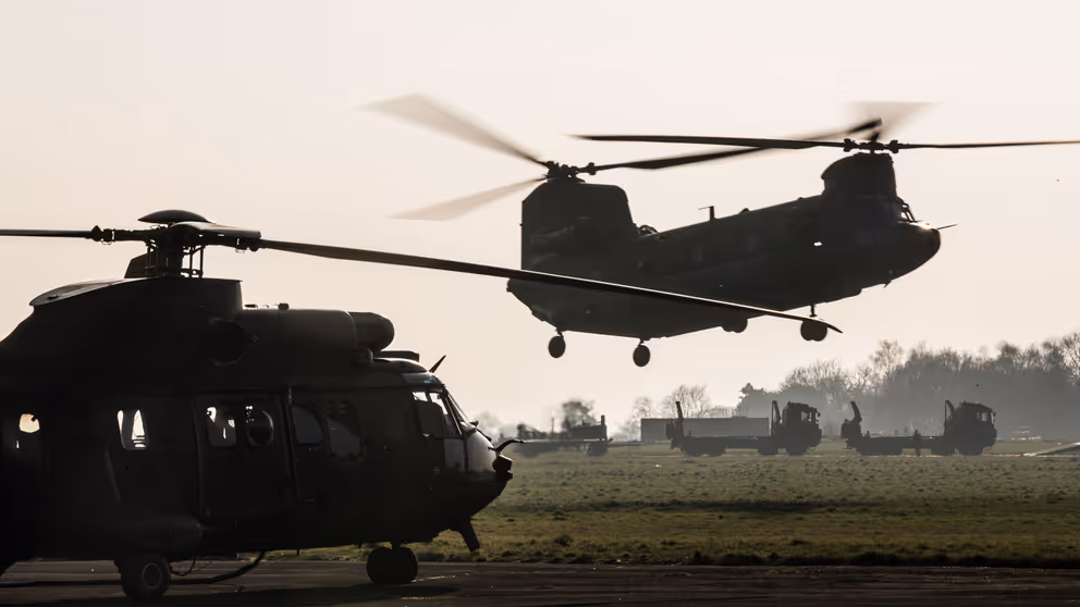 Chinook-transporthelikopter landt op open veld.
