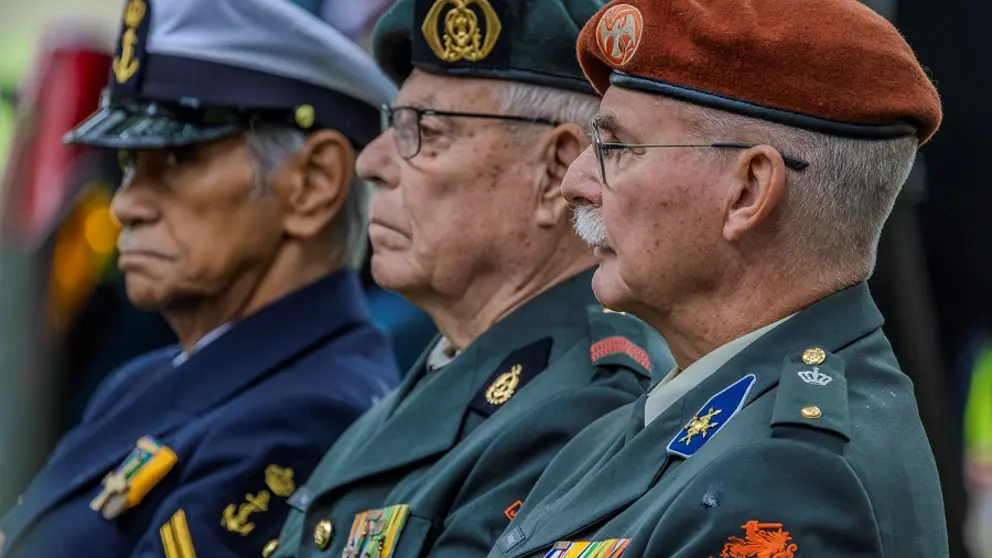 3 oud-militairen staan naast elkaar bij de herdenking