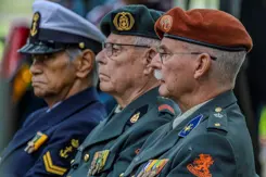 3 oud-militairen staan naast elkaar bij de herdenking