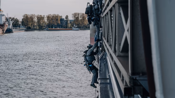 Een militair daalt af van een ladder.