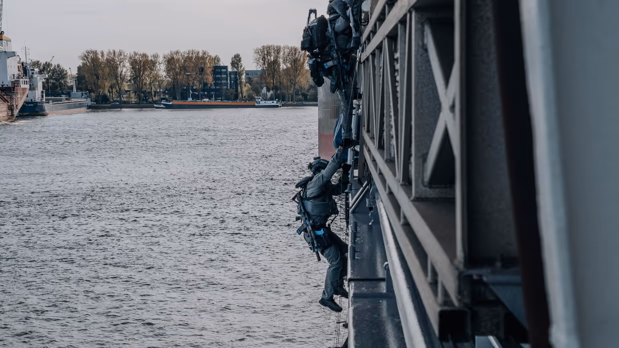 Een militair daalt af van een ladder.