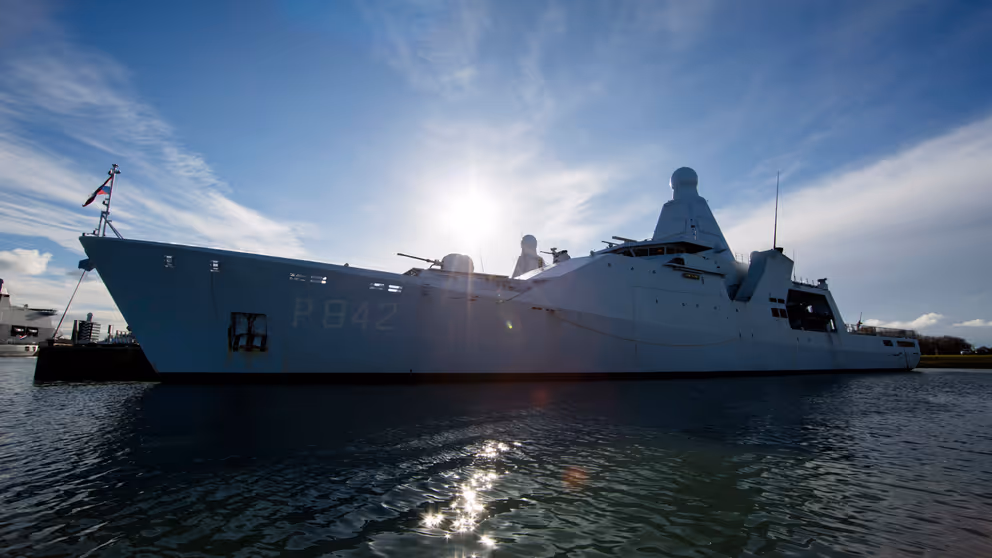 Marineschip gefotografeerd tegen de zon in.