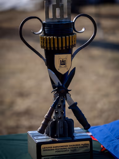 Links: een militair met wapen, rechts: een bokaal.