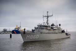 Mijnenjager M860 vaart een haven binnen.