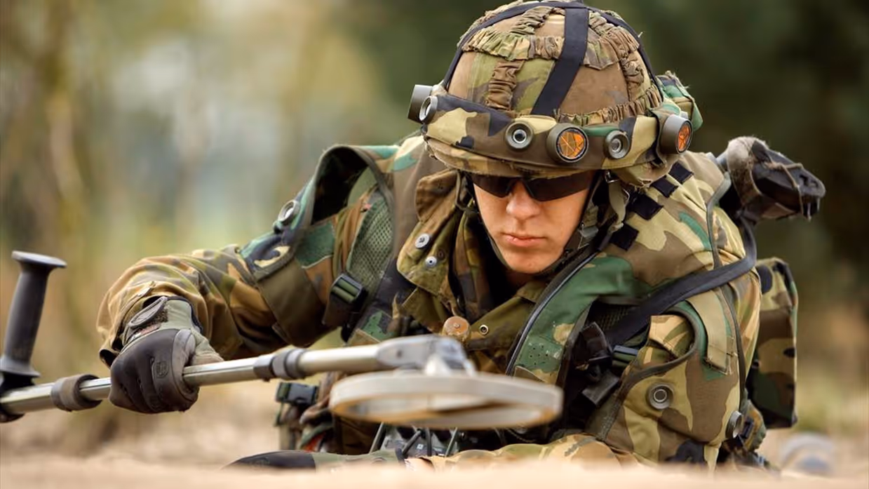 Een militair aan de slag met een metaaldetector.