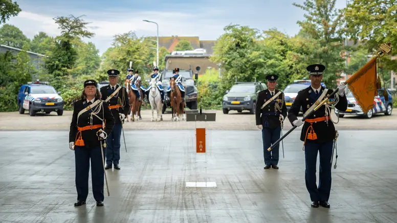 De oude en de nieuwe C-KMar staan opgesteld met het vaandel in de hand.