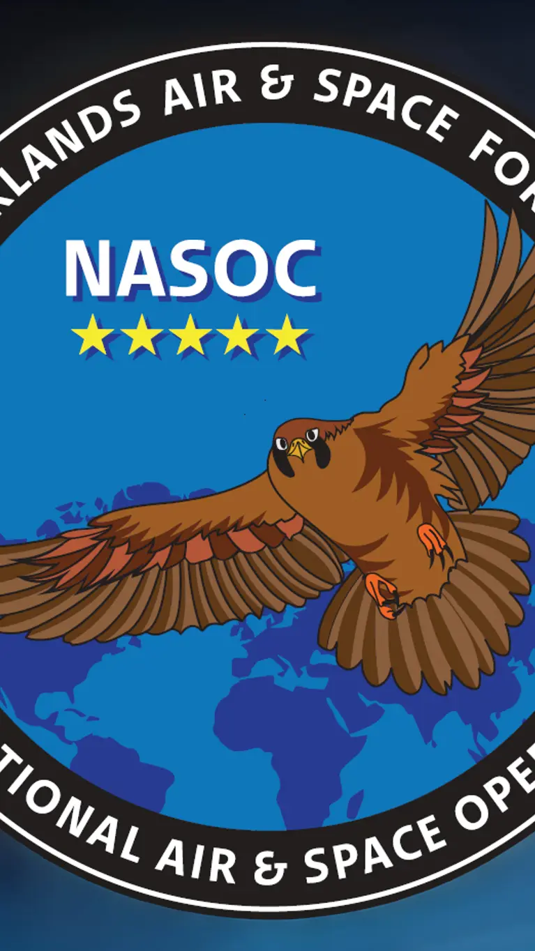 Tegen een blauwe achtergrond het ronde logo van het NASOC: een bruine adelaar die over een blauwe wereldbol vliegt. In de rand om het logo staat Royal Netherlands Air & Space Force – National Air & Space Operations Center.
