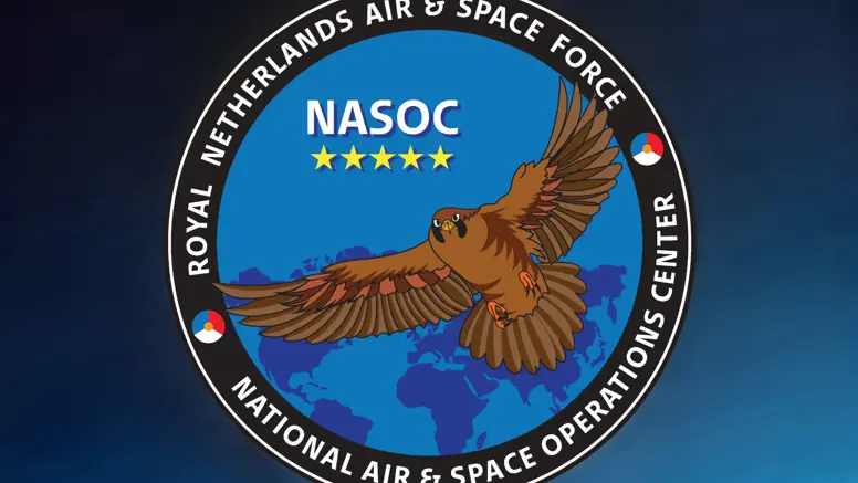Tegen een blauwe achtergrond het ronde logo van het NASOC: een bruine adelaar die over een blauwe wereldbol vliegt. In de rand om het logo staat Royal Netherlands Air & Space Force – National Air & Space Operations Center.