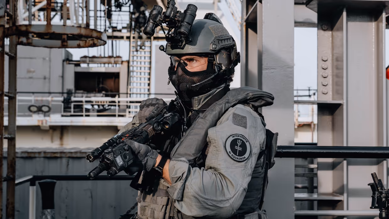 Bewapende marinier van speciale eenheid vlakbij een schip in een haven.