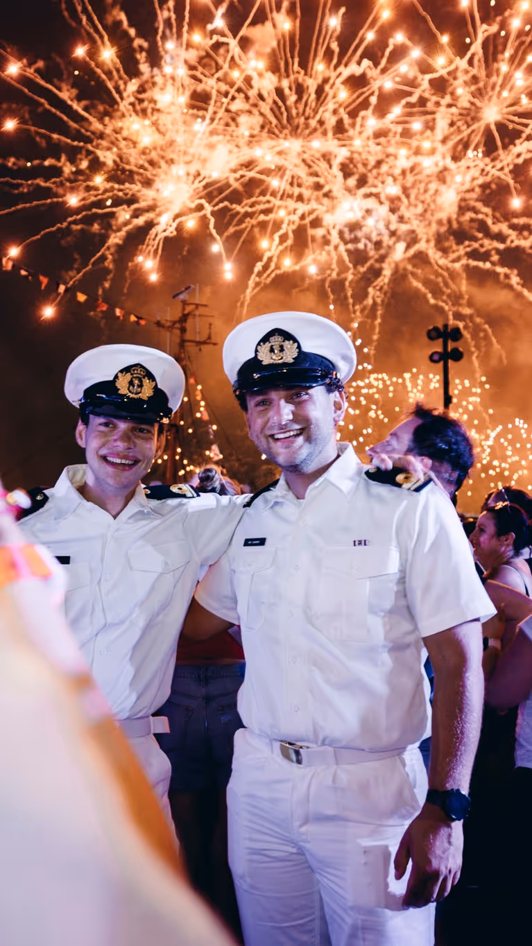 Oplichtend vuurwerk met daarvoor een aantal marinemannen.