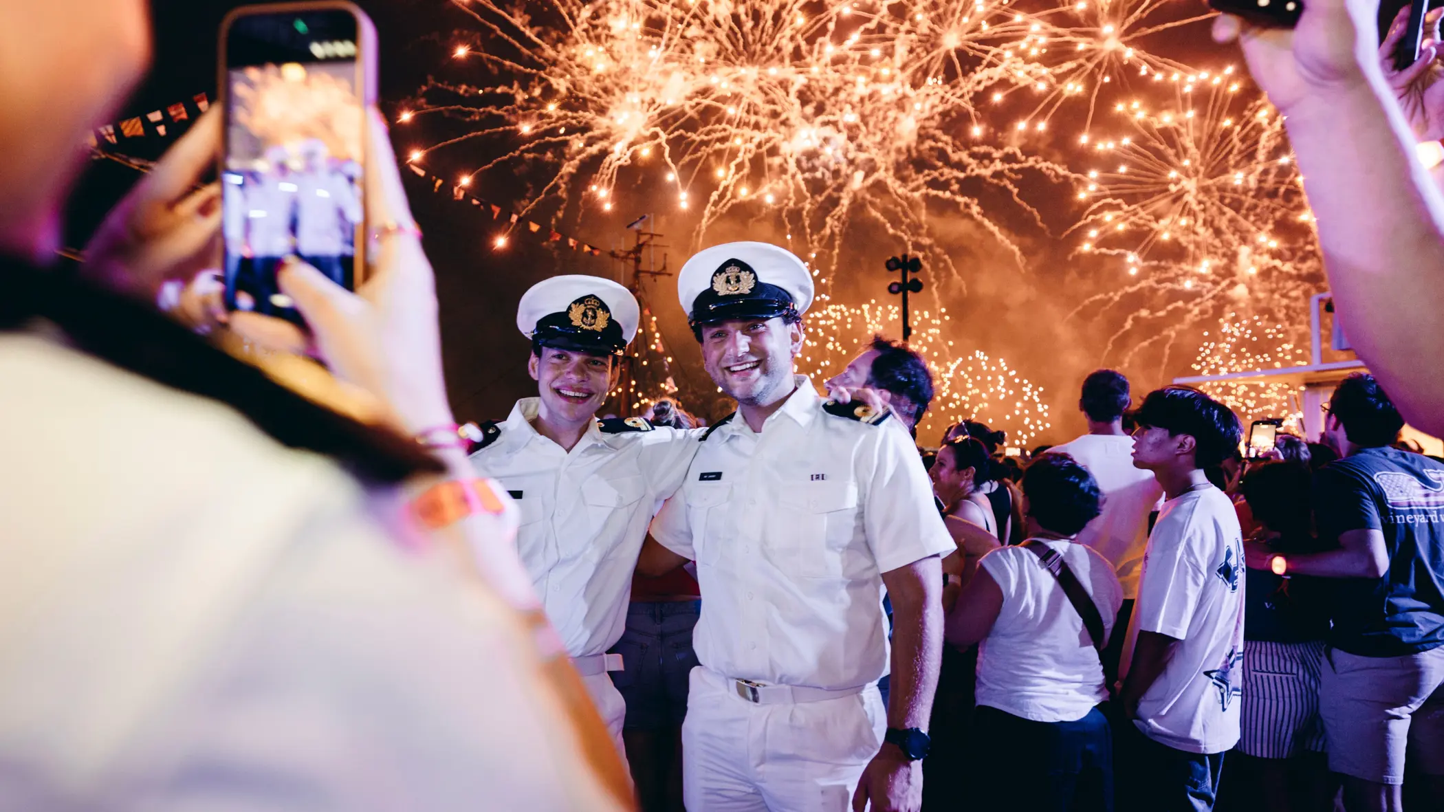 Oplichtend vuurwerk met daarvoor een aantal marinemannen.