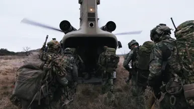 Militairen in het veld stijgen een Chinook in. 